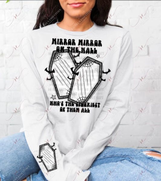 Model wearing a white sweatshirt with a halloween design on the front and sleeve of the sweatshirt. The front has the wording Mirror Mirror on the wall who's the spookiest of then all. Between the wording is 2 black coffins with spider webs and bats. The same design is featured on the sleeve of the sweatshirt 