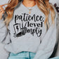 a model wearing a grey sweatshirt featuring a halloween design. The design has the words patience level empty with a low leve battery life and a skeleton hand throwing up the peace sign. 