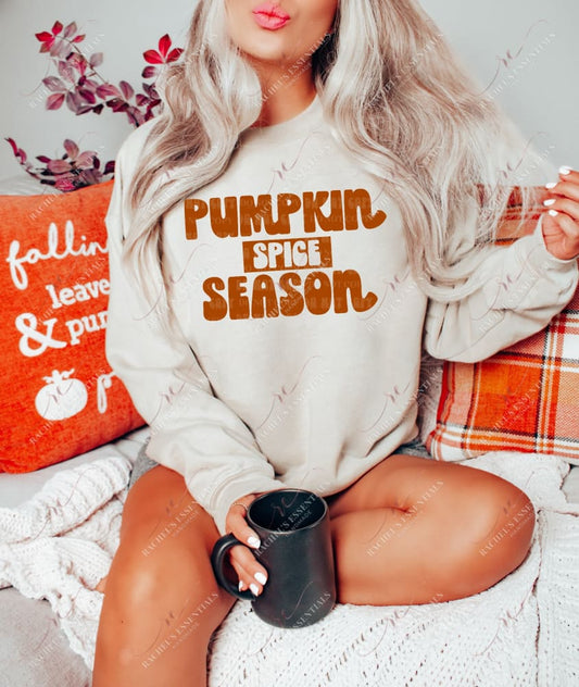 blonde model wearing a tan sweatshirt with orange words saying pumpkin spice season