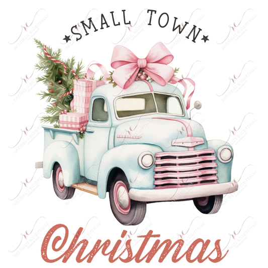 light blue & pink vintage truck with a large pink bow on top. The back of the truck is filled with pink wrapped presents and a green christmas tree